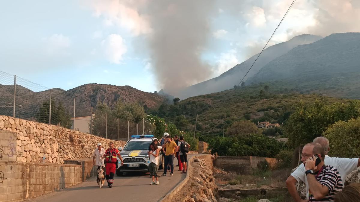 Desalojo de las casas de la partida Verdales. Al fondo, la columna de humo que revela la cercanía de las llamas