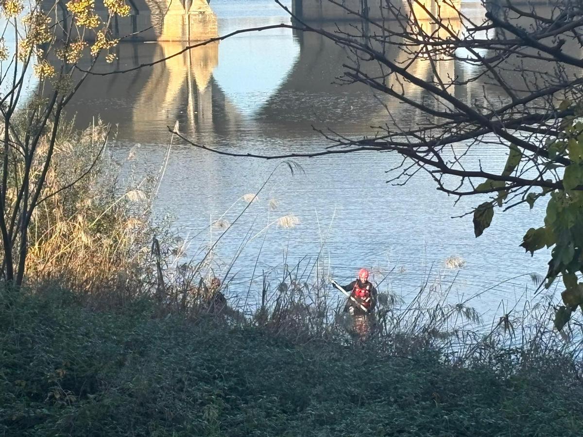Uno de los voluntarios durante las labores de búsqueda en la orilla izquierda del río Guadiana a su paso por Badajoz.