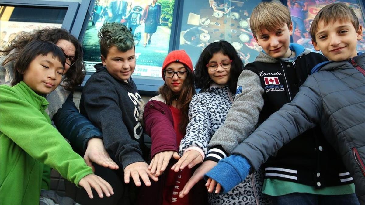 Un grupo de niños, algunos de ellos con fisura labial, juntan sus manos antes de entrar en el cine para ver la película 'Wonder', el domingo pasado en Cerdanyola.