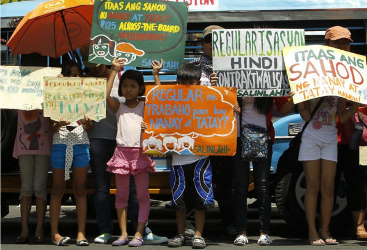 Niños filipinos sostienen pancartas durante una manifestación en Manila.