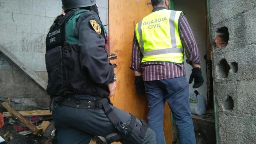 Dos agentes de la Guardia Civil entran en una chabola en O Vao durante la operación.