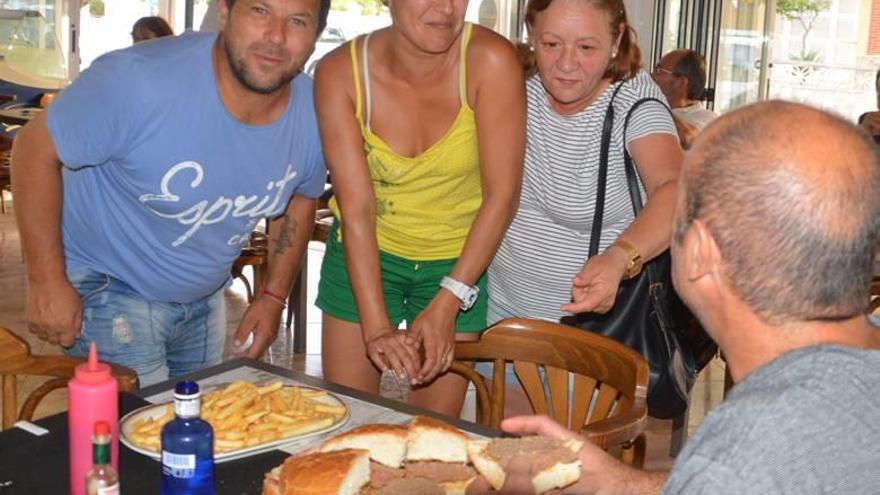 Los propietarios del Bar Castellet de Cala Rajada, junto al último valiente en intentar la locura, Sebastià Duran, y la mastodóntica hamburguesa.