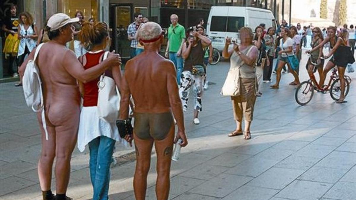 Dos nudistas en los aledaños de la plaza de la Catedral, en pleno barrio Gótic.