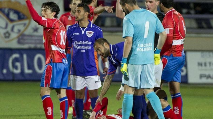 El delantero del Ourense Óscar Martínez, en el suelo, se lleva la mano a su cabeza ensangrentada. // Área 11