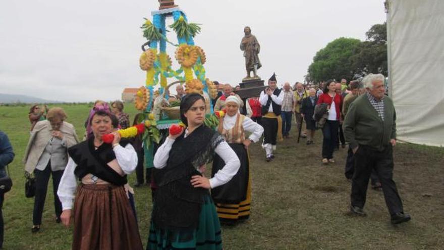 Varias mujeres vestidas de aldeanas llevan a hombros el ramu, tras el que los hombres traen la imagen de San Isidro Labrador durante la procesión.