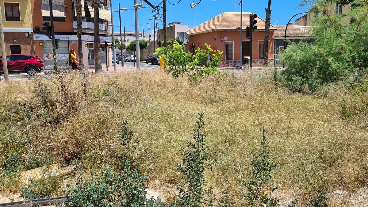 Suciedad y maleza en un solar de la calle La Huerta.