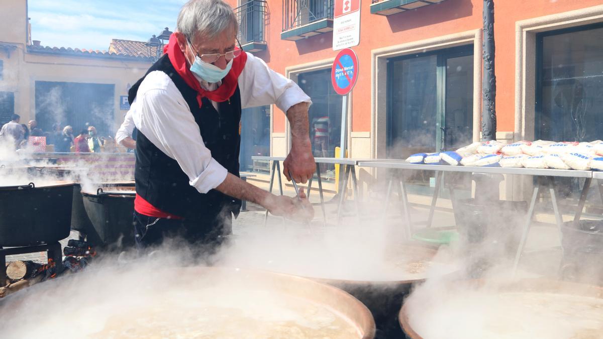 Un membre de la comissió de ranxo remenant una olla