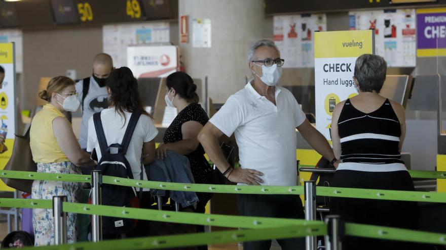 Varios viajeros esperan en el aeropuerto de Manises.