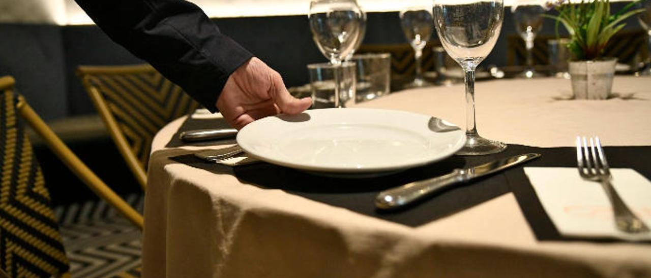 Un camarero prepara la mesa en un restaurante.