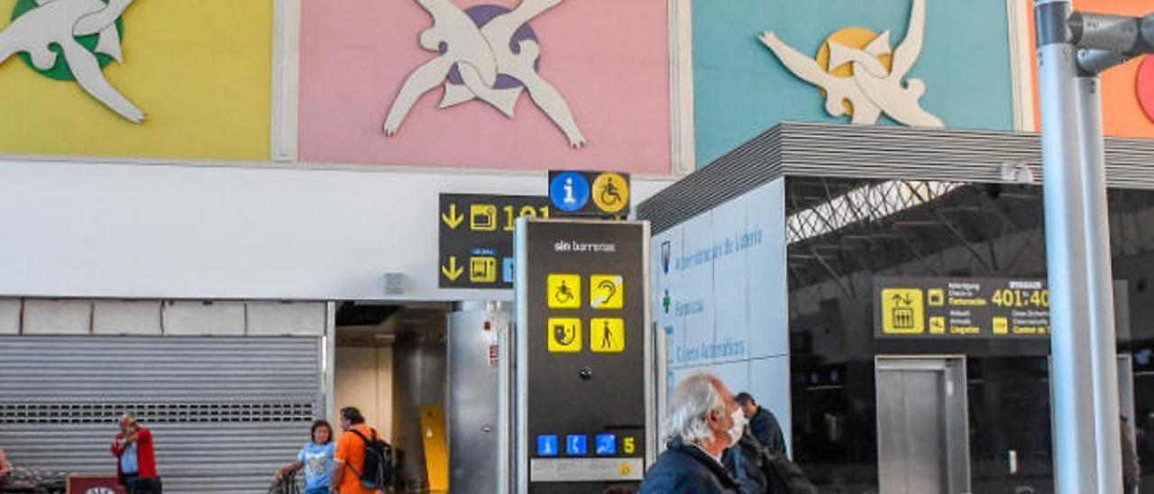 Varios turistas esperan en el aeropuerto de Gran Canaria.