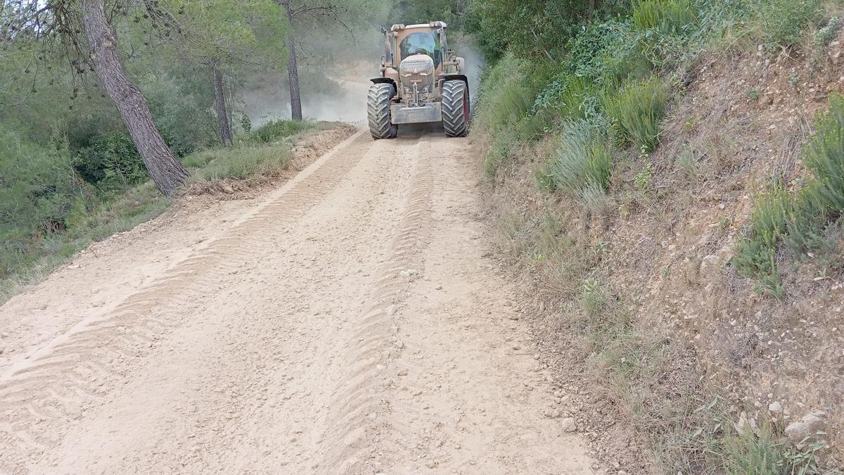 Una máquina trabajando en la adecuación de un camino en Vallada.