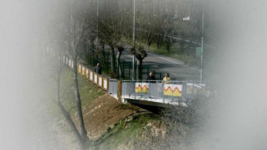 Vecinos caminando por la pasarela de la senda de la ría a la altura de La Marzaniella.