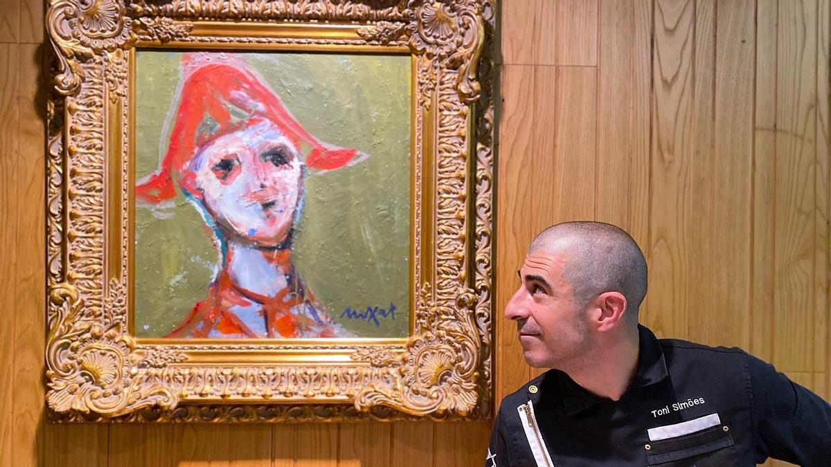 Simões mira uno de los cuadros de La Taverna del Clínic.