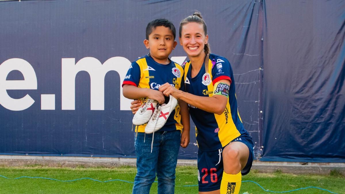 Marta Perarnau junto a un aficionado del Atlético de San Luis en el Dia del Niño