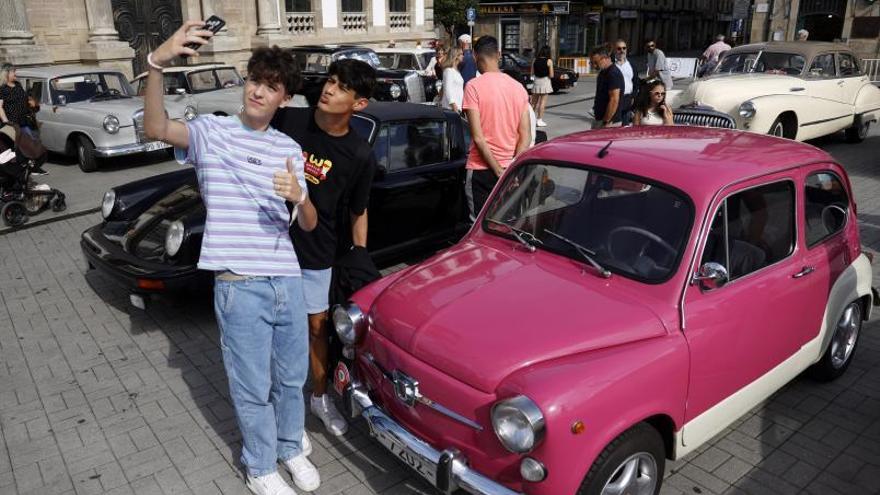 Dos jóvenes se sacan un selfie con un Seat 600 fucsia.