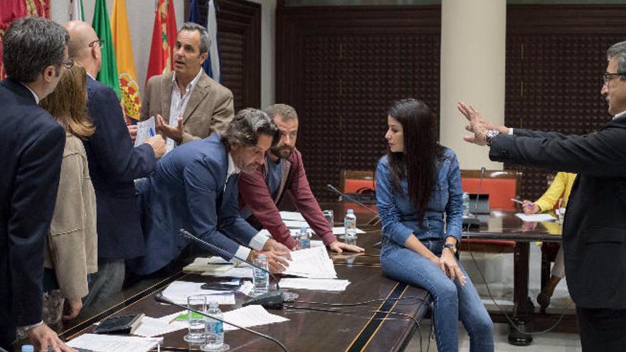 Gustavo Matos y Juan Márquez revisan unos documentos ante la mirada de Melodie Mendoza, sentada en la mesa, durante la comisión de control de RTVC.