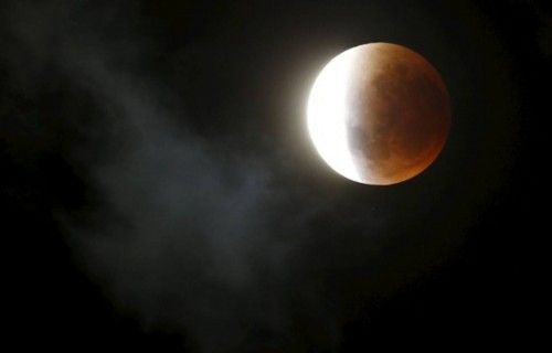 Clouds pass over as the moon is partially covered by the Earth's shadow during a total lunar eclipse in Cape Town