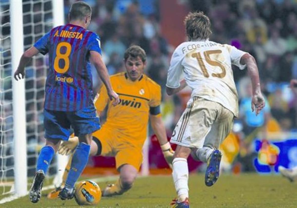 Iniesta intenta batre Casillas, després de driblar Coentrao, en el partit de dissabte a Madrid.