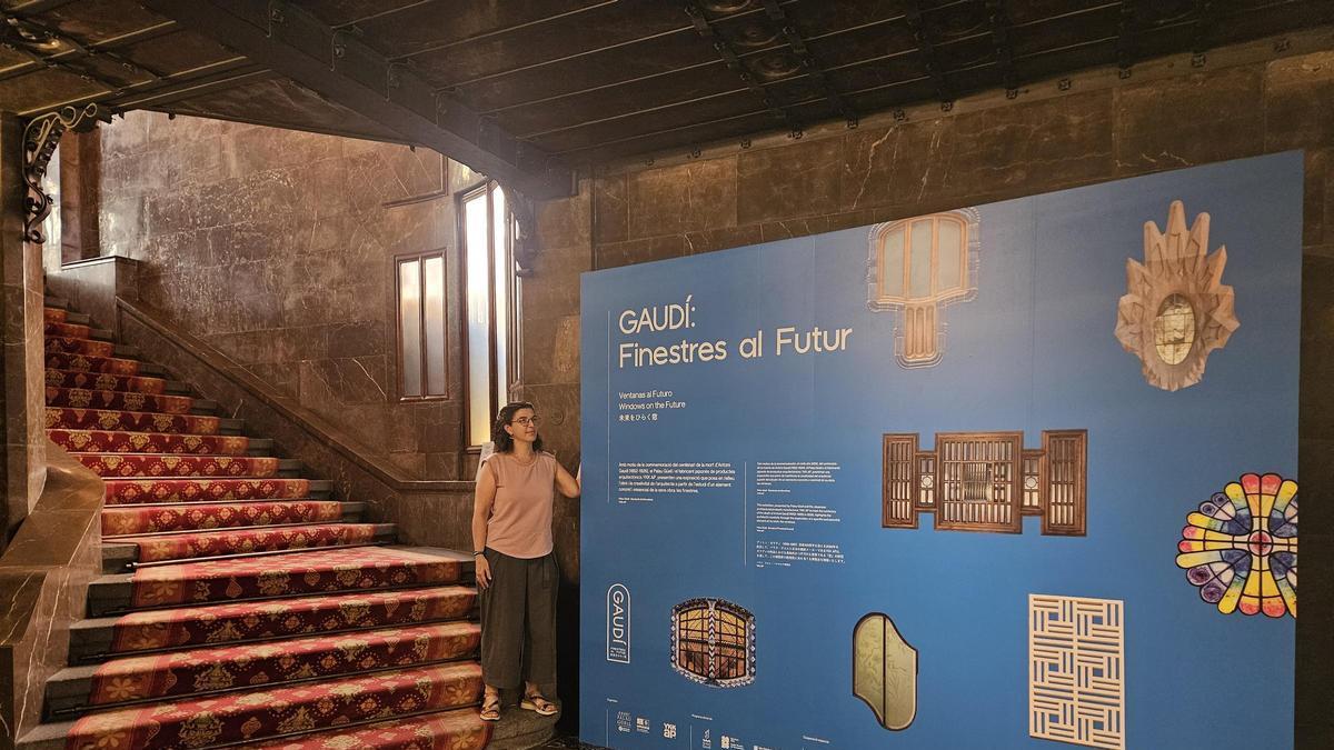 Gal·la Garcia Casarramona, comissària local de l’exposició, amb el plafó promocional a les escales del Palau