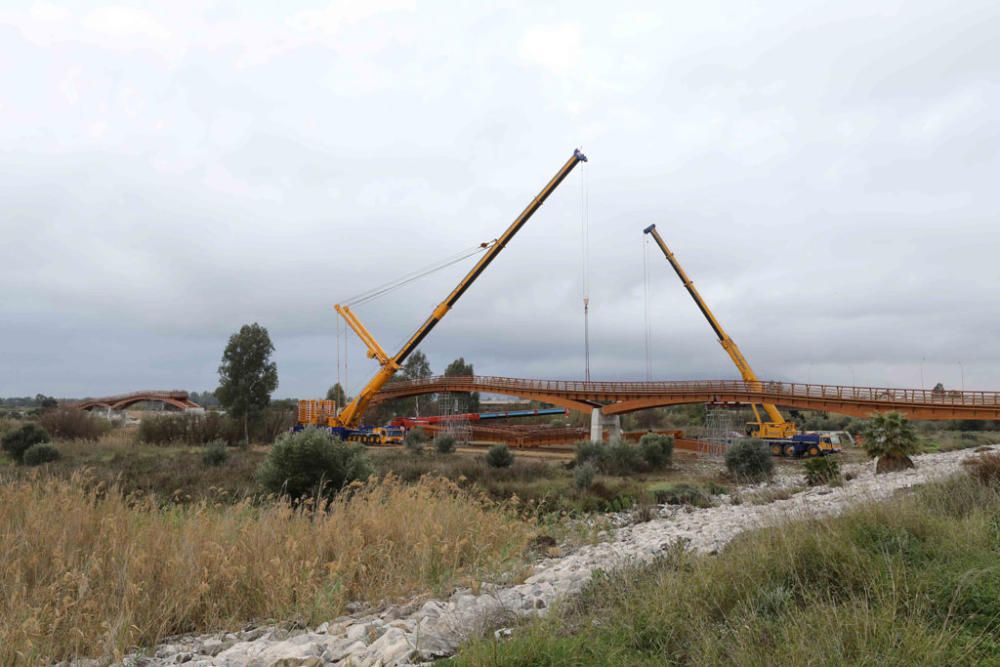 La instalación del último tramo del puente de madera sobre el río Guadalhorce ha comenzado este martes.