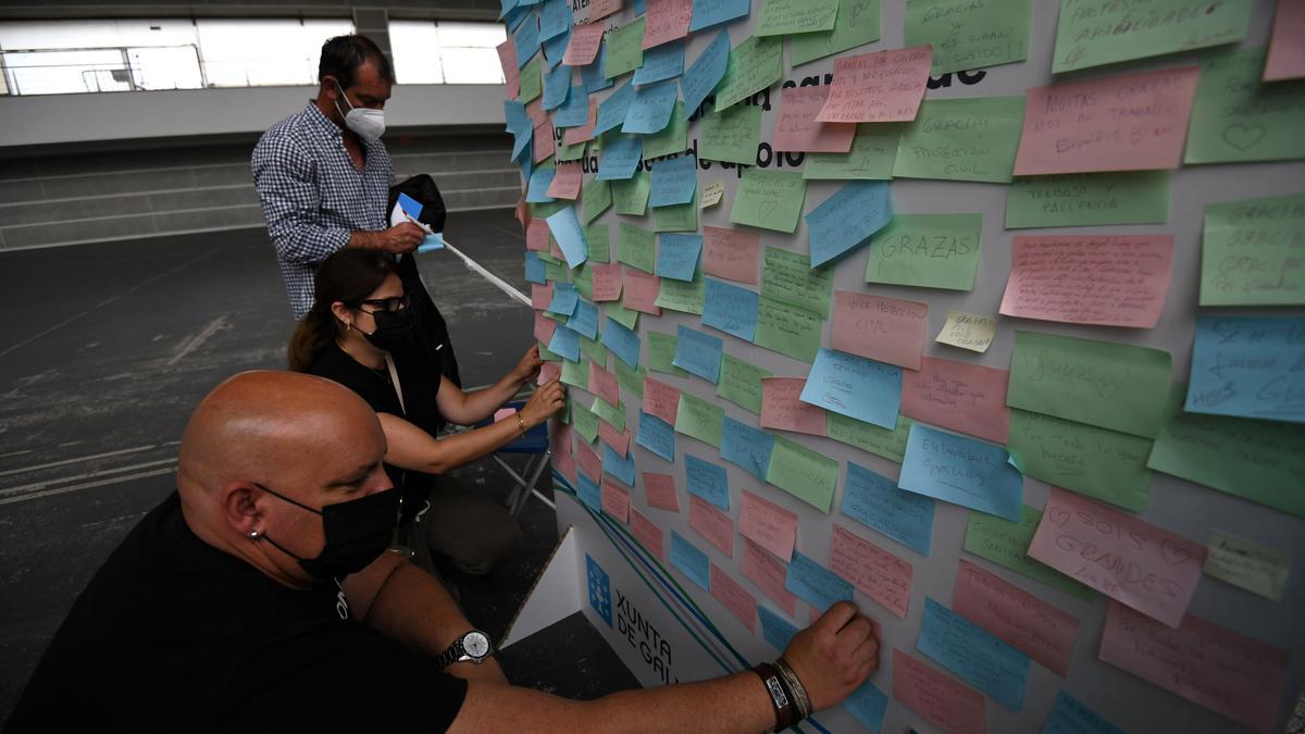 Varias personas escriben mensajes de agradecimiento en el panel del Recinto.