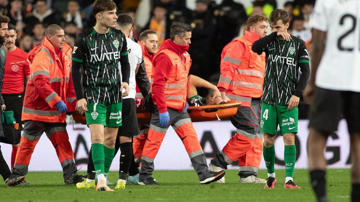 Pedro Bigas abandona Mestalla en camilla tras el choque con Lucas Beltrán.
