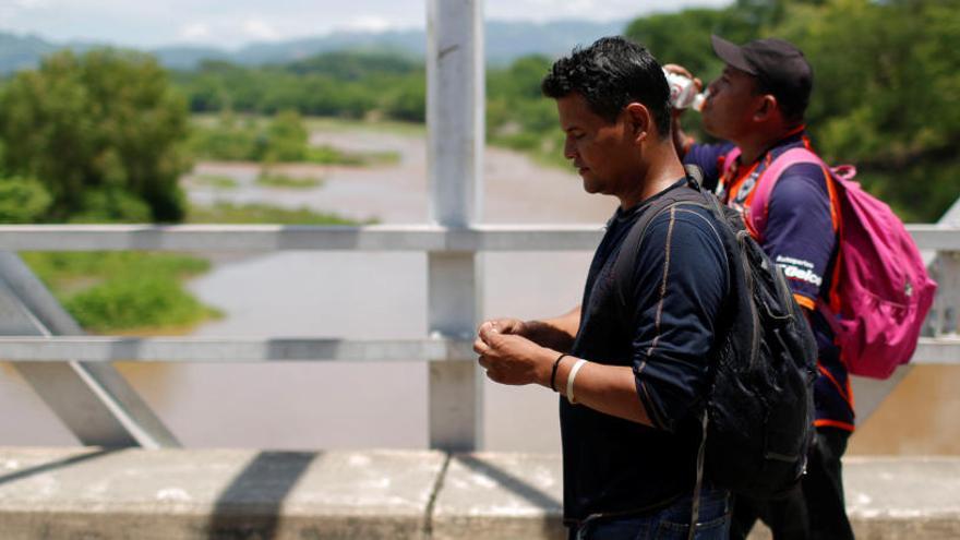 Dos migrantes cruzan desde El Salvador hasta Guatemala.