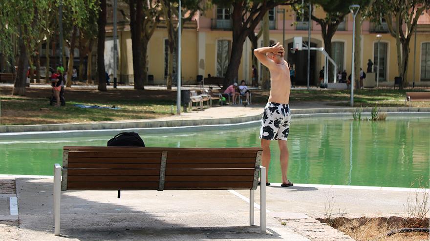 Un jove en banyador es remulla a la vora del llac del parc de l'Espanya Industrial de Barcelona