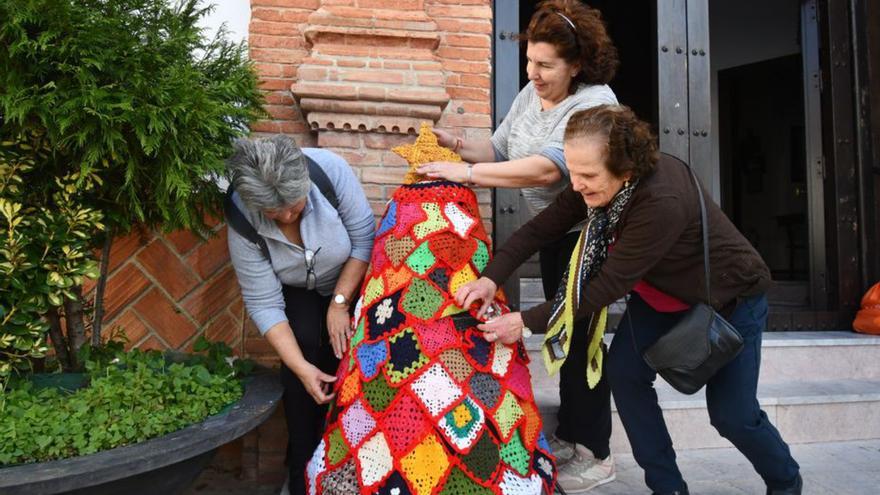 Vecinas de Algatocín junto a un árbol de crochet.