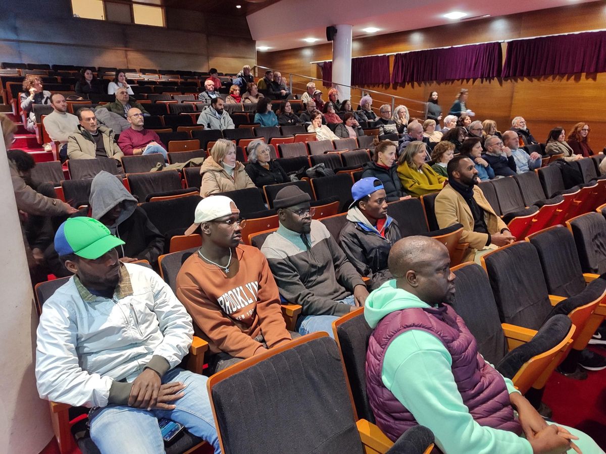 Varios de los migrantes y el numeroso público que acudió ayer a la charla en el Centro Social do Mar de Bueu.