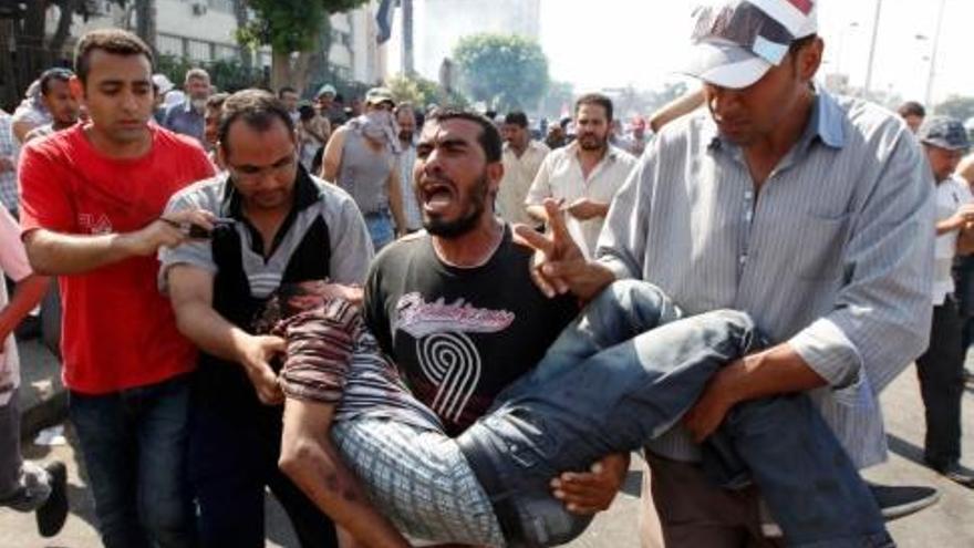 Manifestants favorables al president derrocat Mohamed Mursi porten un company ferit.