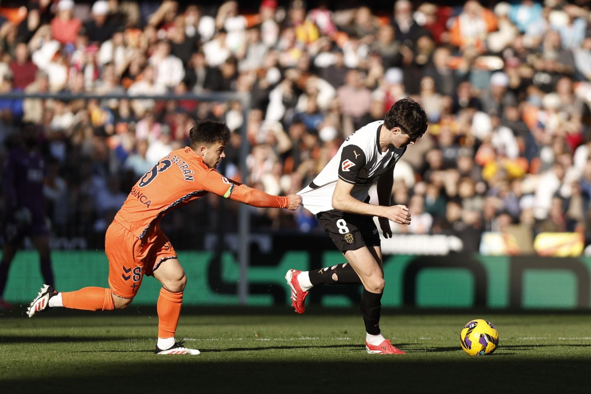 El centrocampista del Valencia Javier Guerra (d) pelea un balón con el centrocampista del Celta Fran Beltrán durante el partido de LaLiga entre el Valencia y el Celta de Vigo, este domingo en el estadio de Mestalla. EFE/ Biel Aliño. (Valencia) (Alaves)