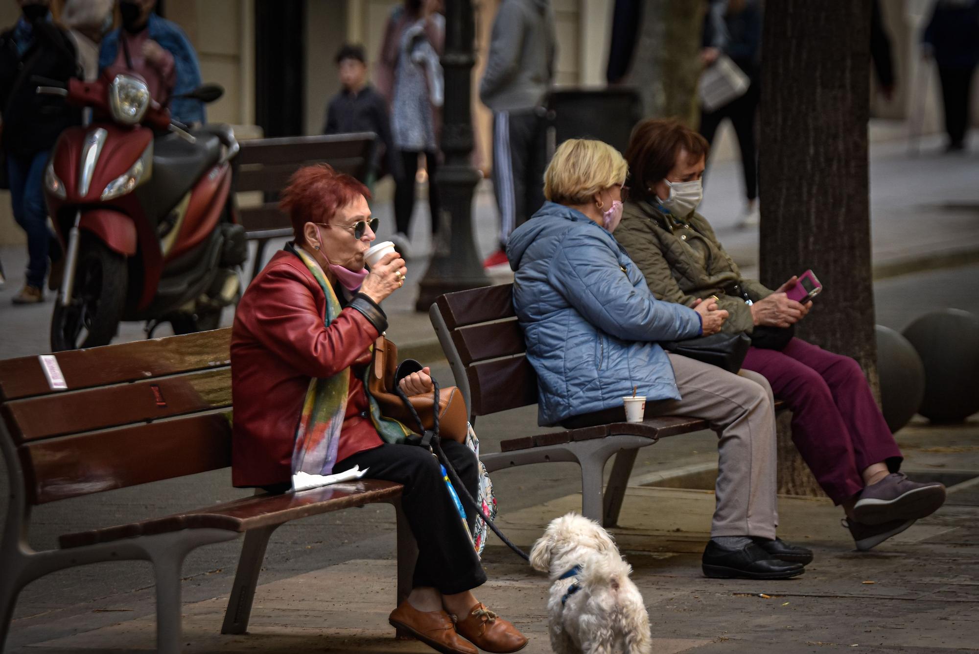 Varias mujeres se sientan en unos bancos en Barcelona.