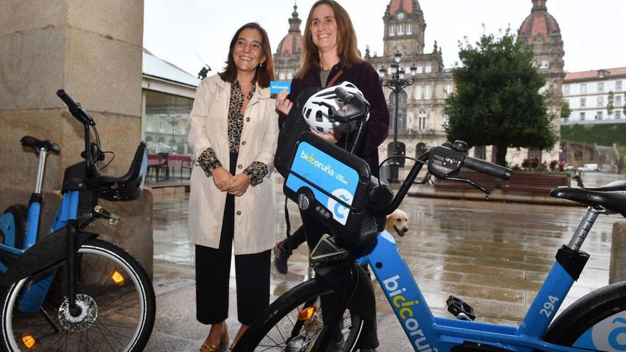 Inés Rey y Olalla Torres, frente al Ayuntamiento, con dos vehículos de BiciCoruña.   | // VÍCTOR ECHAVE