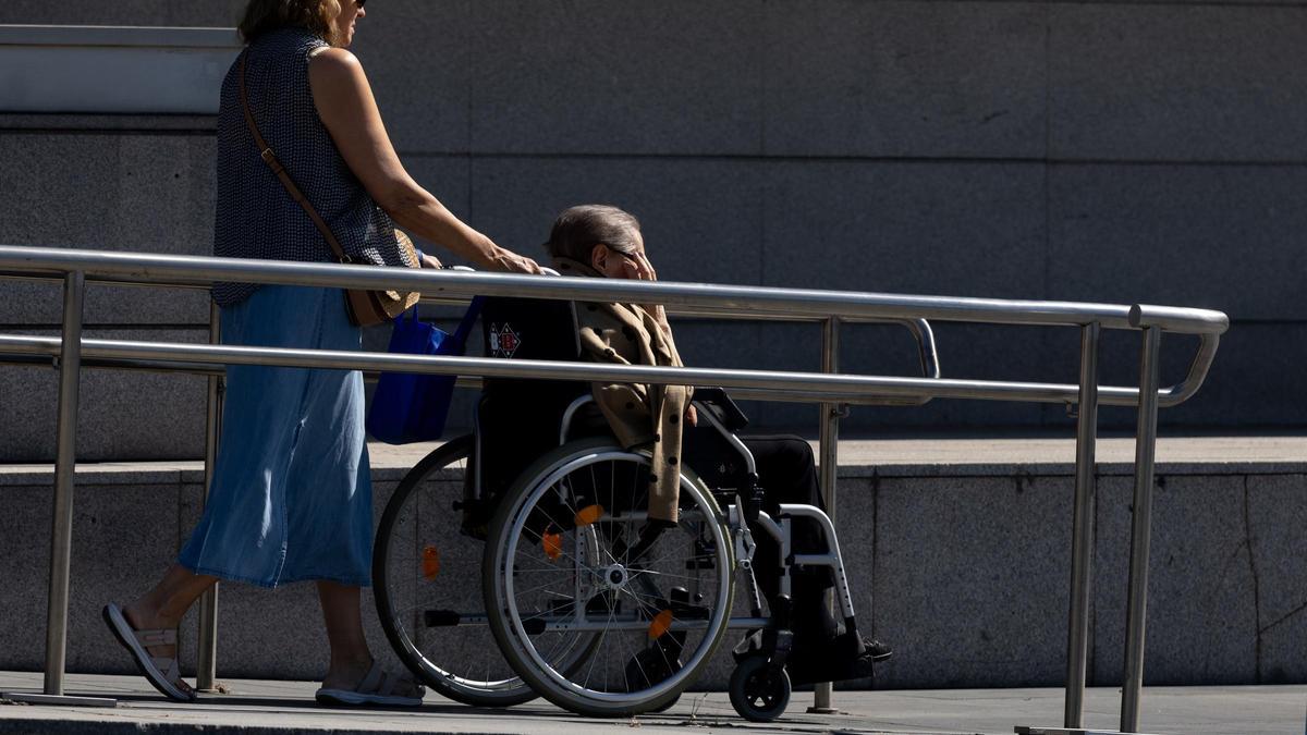 Una persona con discapacidad trasladada en silla de ruedas