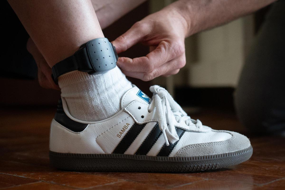 Una persona coloca una pulsera antimaltrato a un hombre.