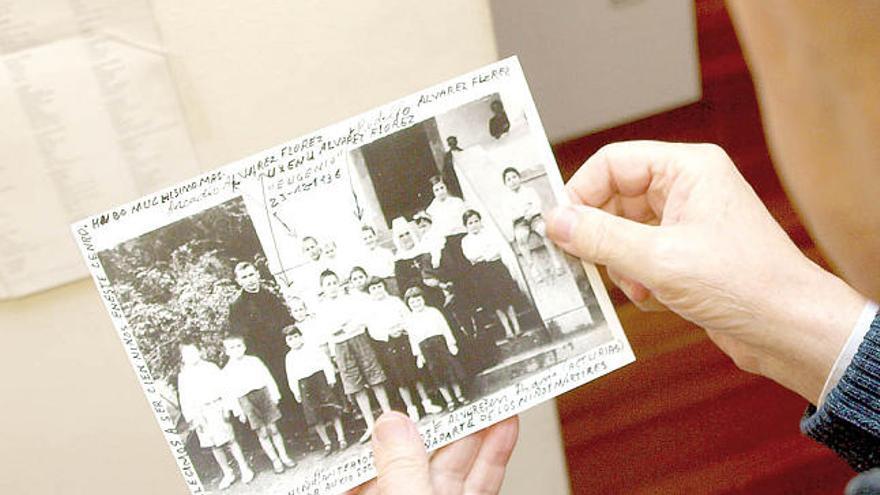 Uxenu enseña una foto suya (el cuarto por la izquierda) en el asilo para niños de Pravia, en 1937.