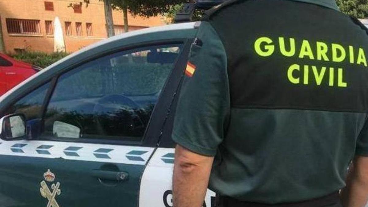 Imagen de archivo de un agente de la Guardia Civil ante un coche patrulla.