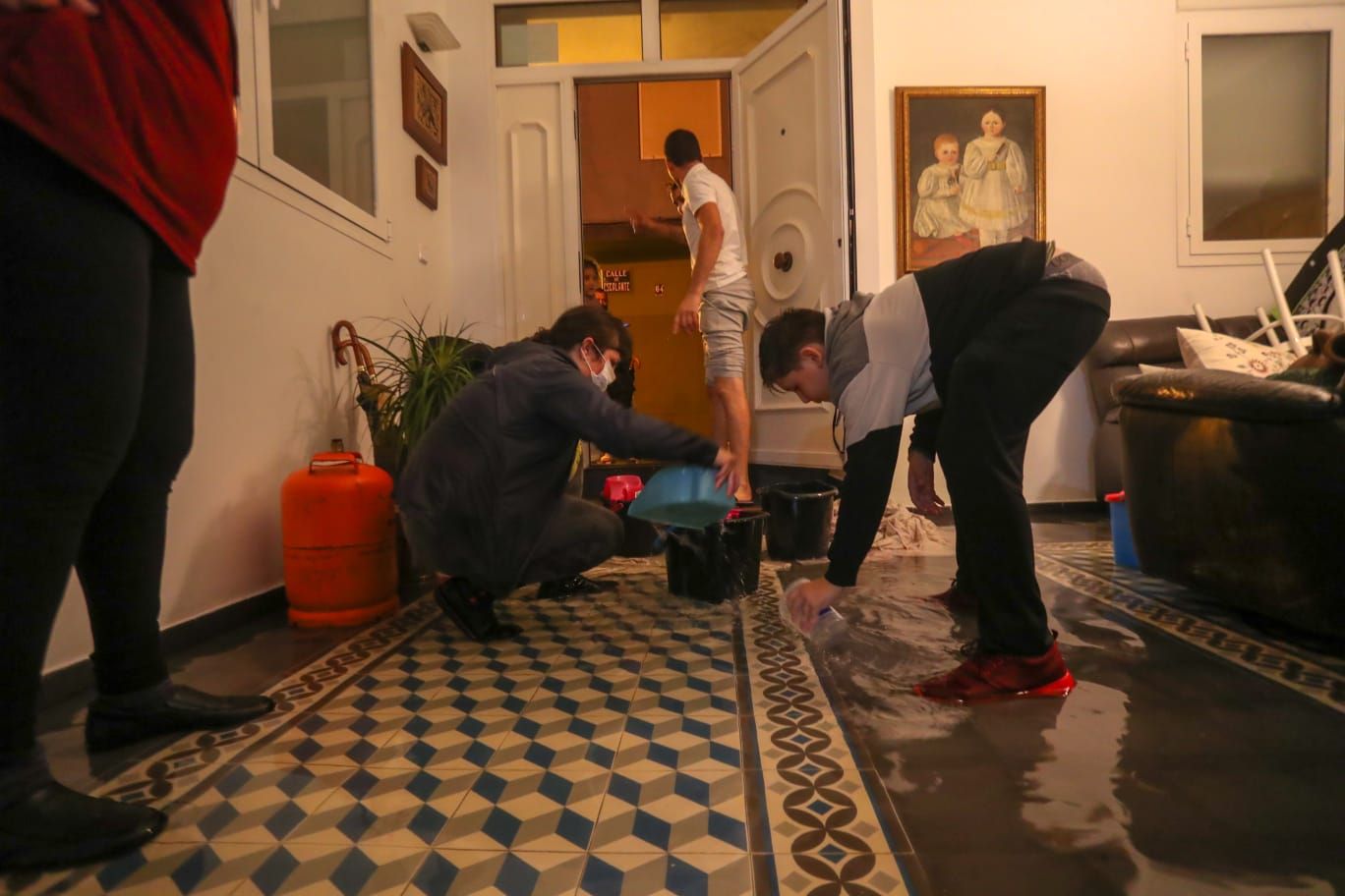 Vecinos del Cabanyal achican el agua que ha entrado en sus casas