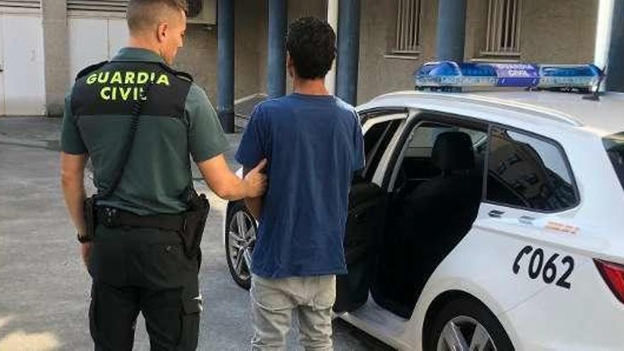 El detenido es introducido en un coche de la Guardia Civil. // G. Civil