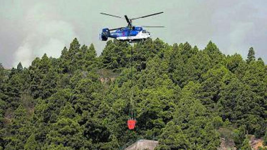 Uno de los helicópteros que participan en la extinción.   | // MIGUEL BARRETO