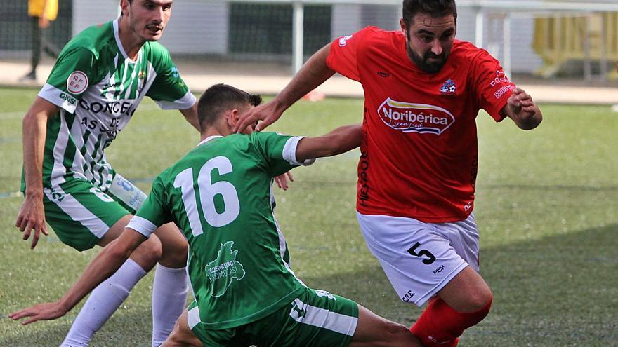 El centrocampista Brais Calvo intenta marcharse de dos jugadores del Somozas. | // BERNABÉ/ANA AGRA