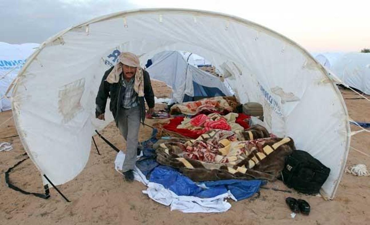 Un refugiat egipci camina dins d’una tenda de campanya en un campament establert a prop del pas fronterer de Ras Jdir, al costat tunisià de la frontera amb Líbia.