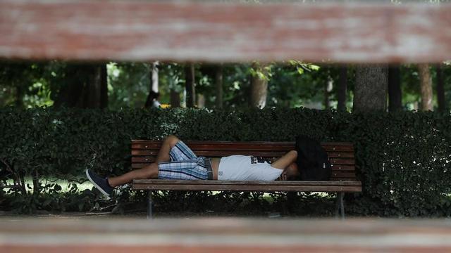 Una mujer descansa en un banco.