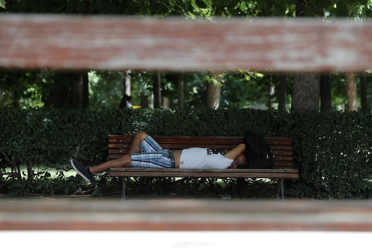 Una mujer descansa en un banco.