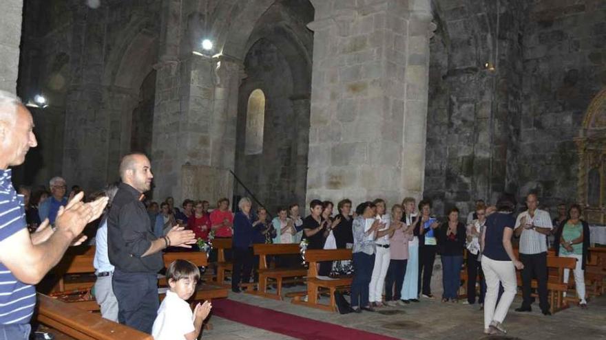 Los vecinos aplauden al párroco José Antonio de la Fuente que, a la derecha, atiende religiosamente a un niño.