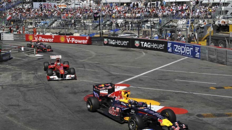 Un momento del apasionante final de carrera de ayer, con Sebastian Vettel frenando los ataques de Fernando Alonso y Jenson Button.