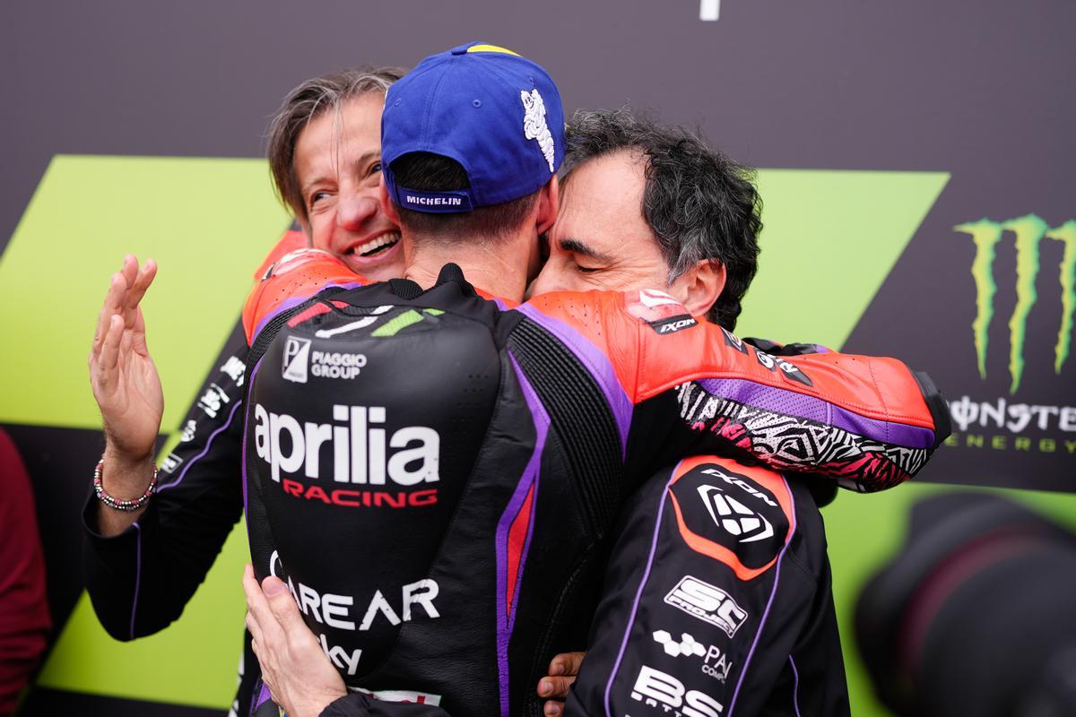Massimo Rivola y Romano Albesiano, máximos responsables del equipo Aprilia Racing, abrazan, emocionadísimos, a Aleix Espargaró.