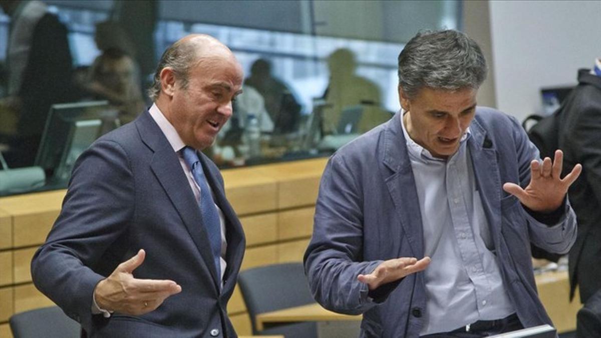 Guindos (izquierda) conversa con el nuevo ministro griego de Finanzas, Euclid Tsakalotos, este martes en Bruselas.