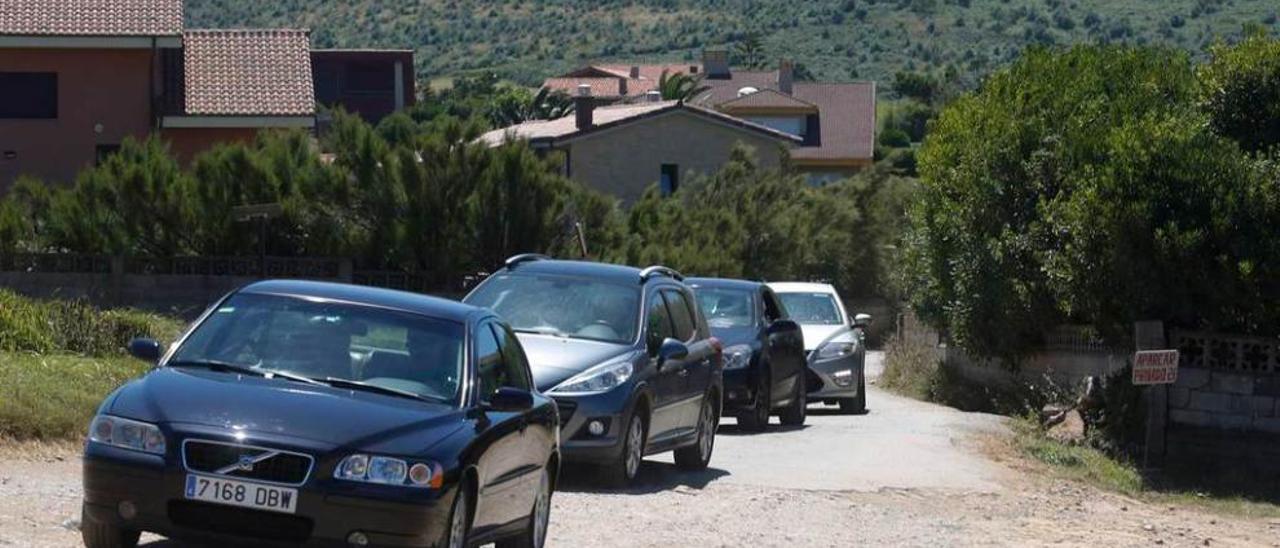 Varios coches en las proximidades de la playa de Verdicio.